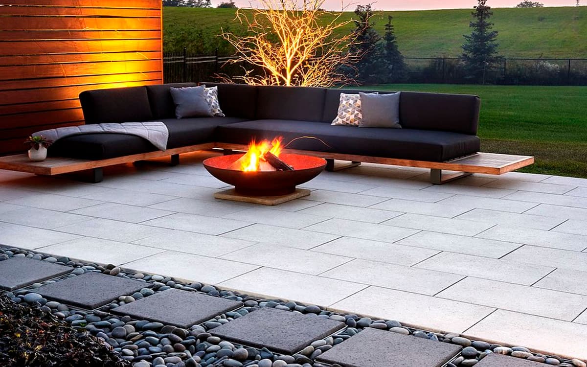 sleek patio with stone pavers, modern seating, and fire bowl created by Expert Hardscaping in Fort Worth, TX