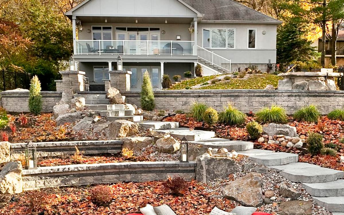 tiered backyard with stone retaining walls, garden steps, and landscape design by Expert Hardscaping in Fort Worth, TX